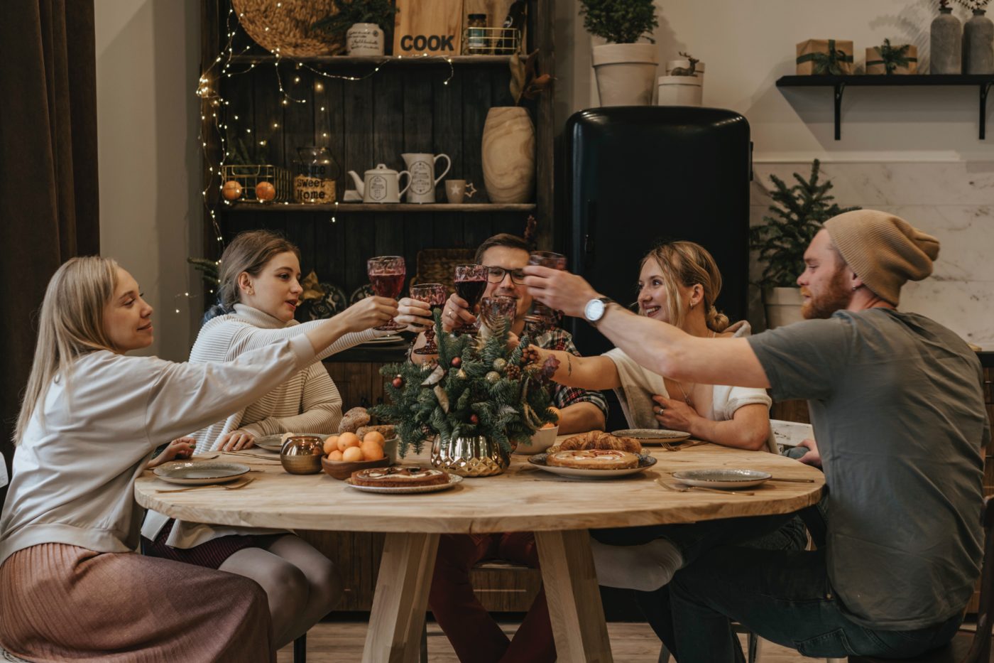 people raising wine glasses around a table