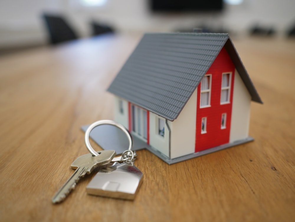 Small toy house next to regular sized house keys