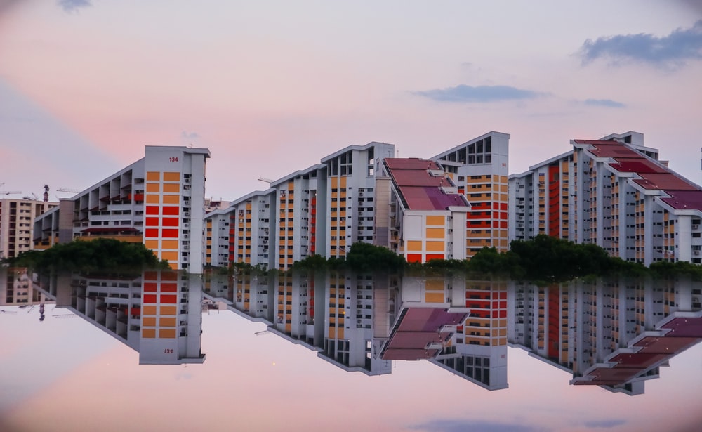 Three large buildings surrounded by water and trees