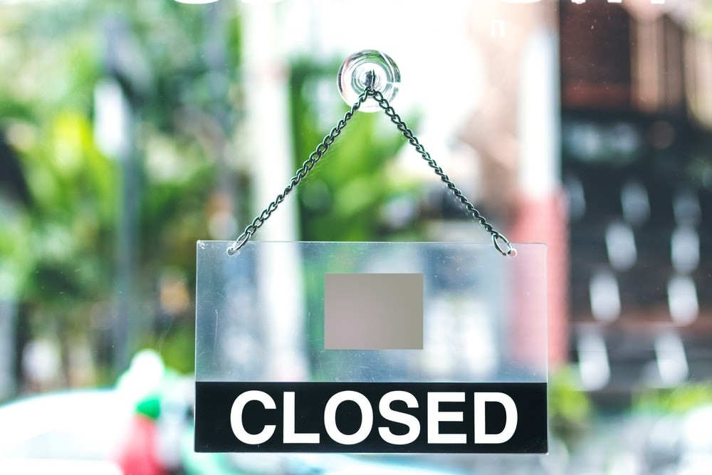 A closed sign on a window with a blurred background