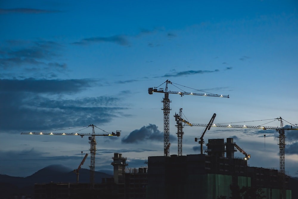 Wide angle shot of building cranes at sunset