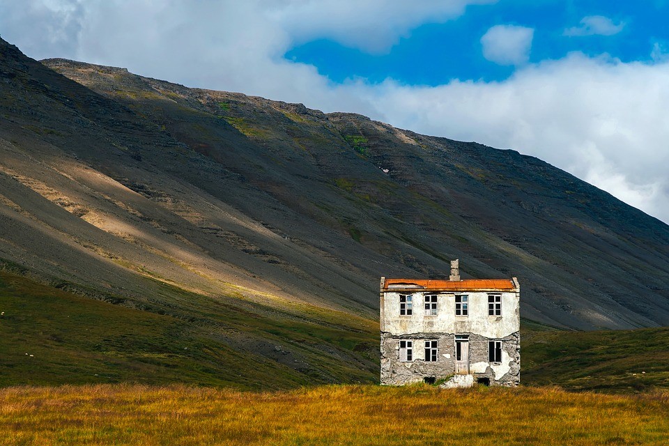 Derelict house beneath a hill