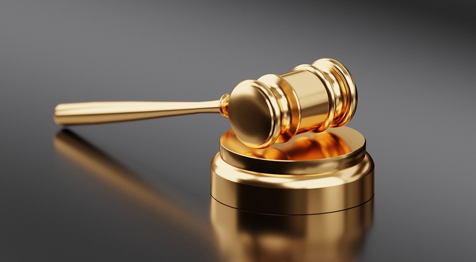 A golden gavel against a reflective surface