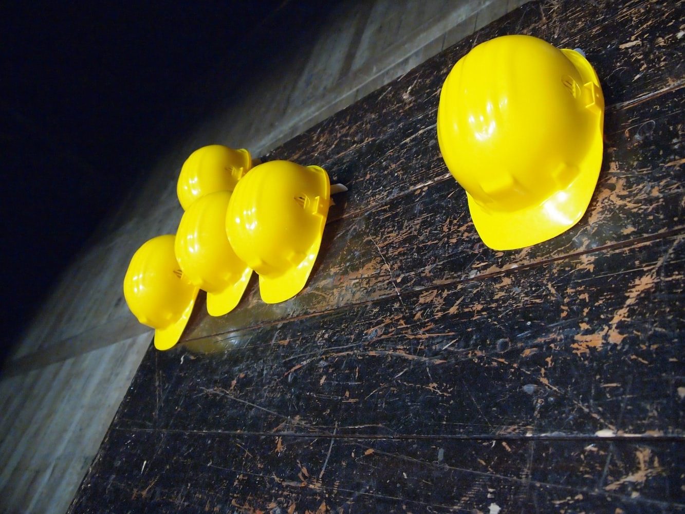 Yellow hardhats on a stressed wood floor