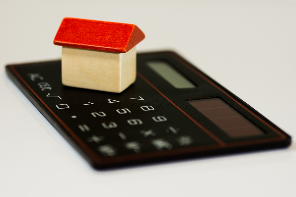 Small toy house on top of a black calculator