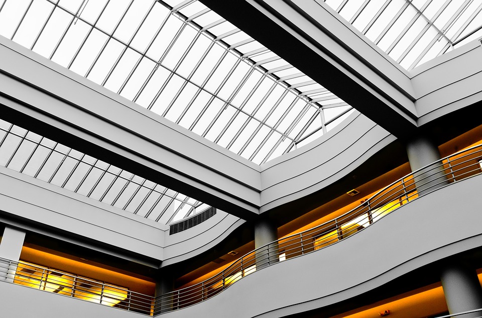 Upwards ceiling shot of a multiple storey building with a white balcony