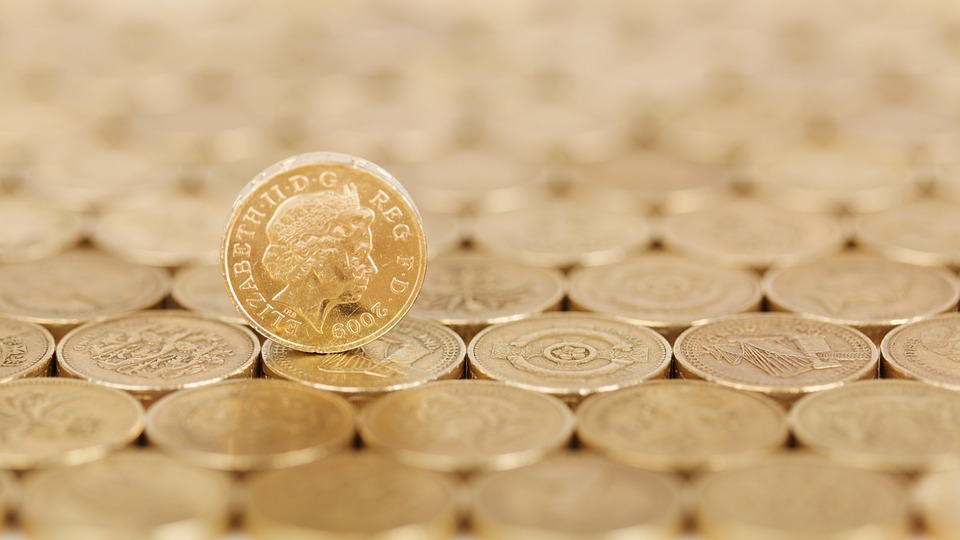 A pound coin standing on other stacked coins