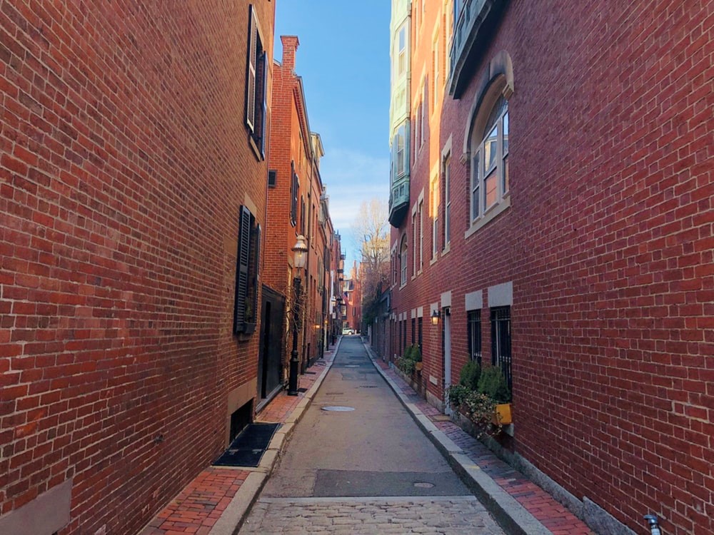 An alleyway between red brick buildings