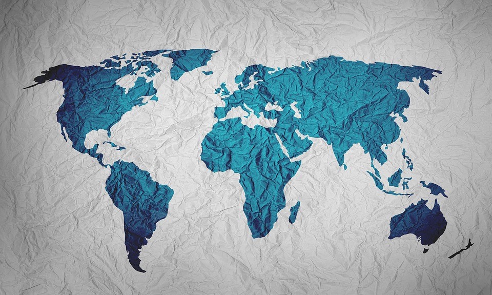 A blue map of the world made from paper