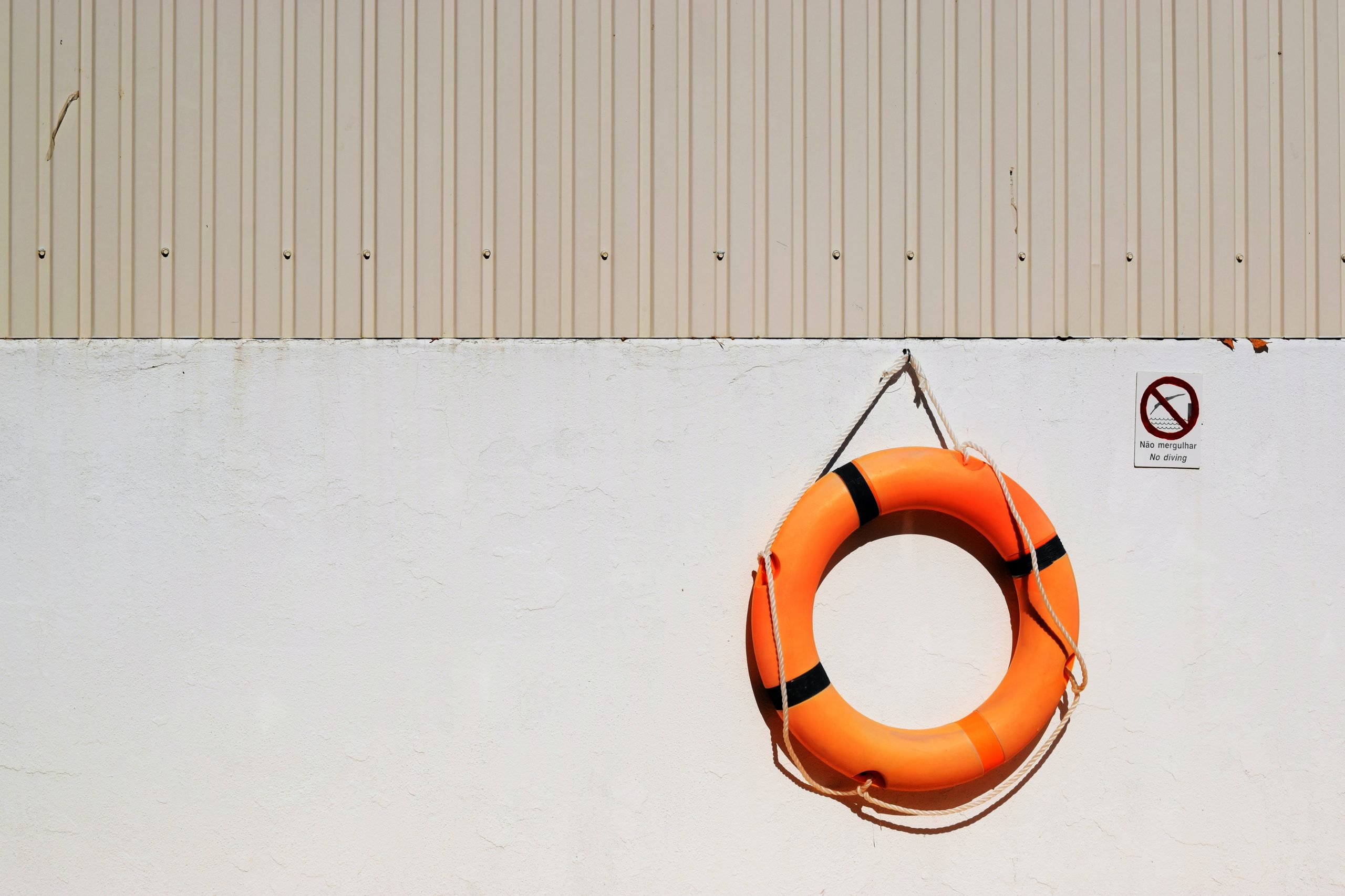 A life buoy hanging on a wall on a sunny day