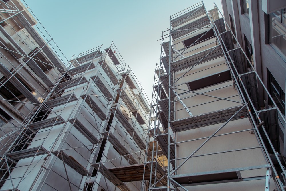 An upward shot of a tall building surrounded by scaffolding