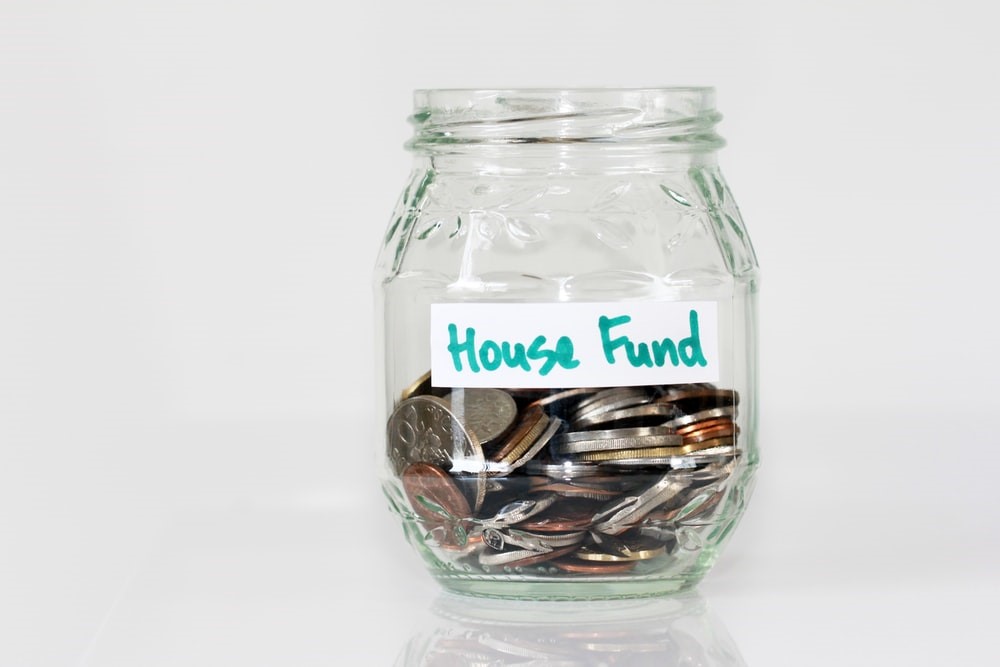 A glass jar labelled "House Fund"
